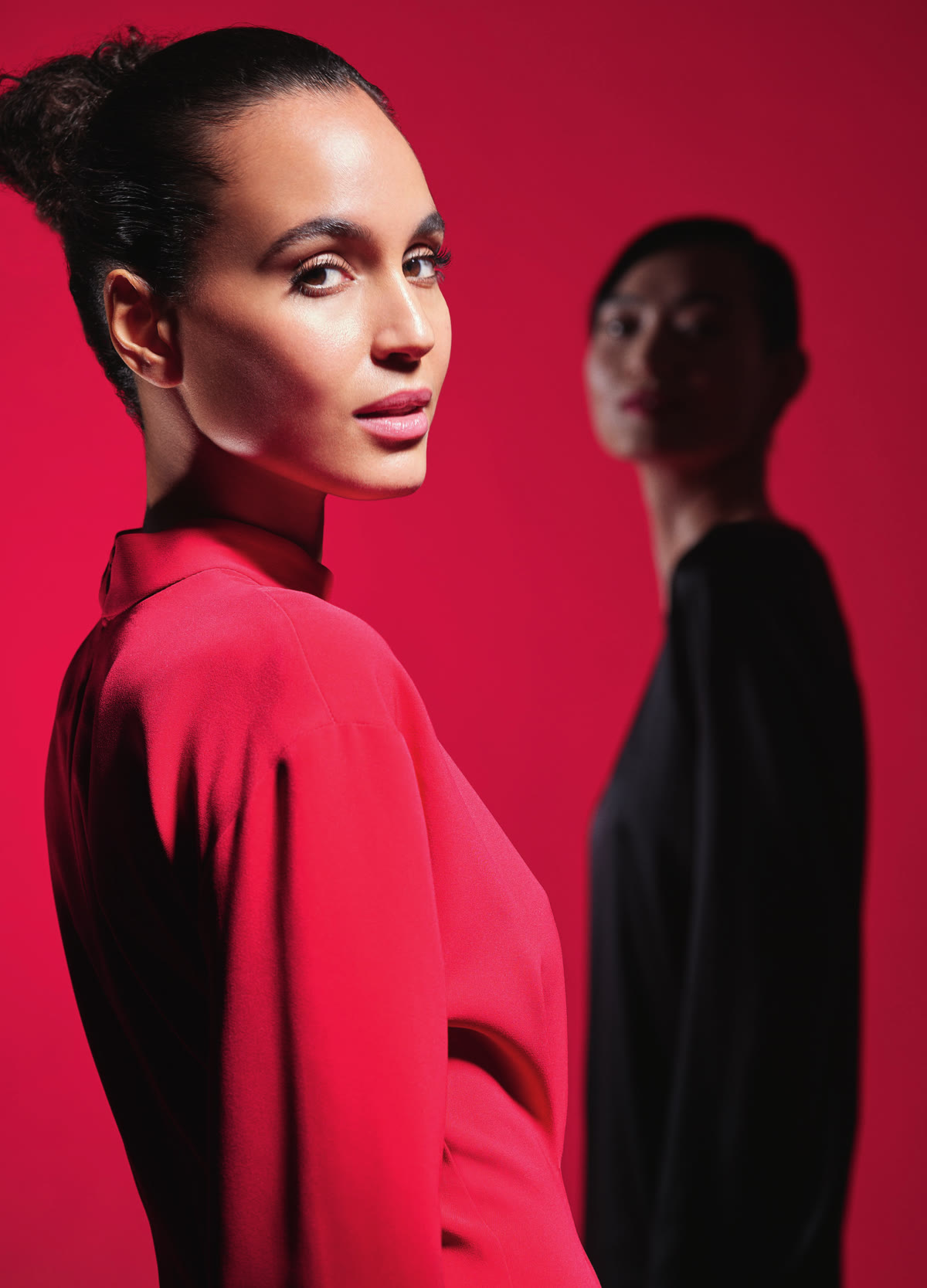 Editorial de campaña Neauvia 2026 — dos modelos sobre fondo crimson